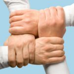 Photo of business peoples hands touching each other